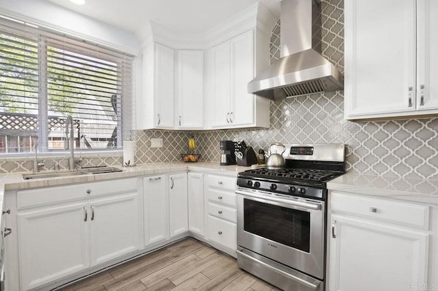 11372 Via Rancho San Diego Unit B, El Cajon, CA 92019 - kitchen featuring gas range, wall chimney range hood, a sink, and light countertops