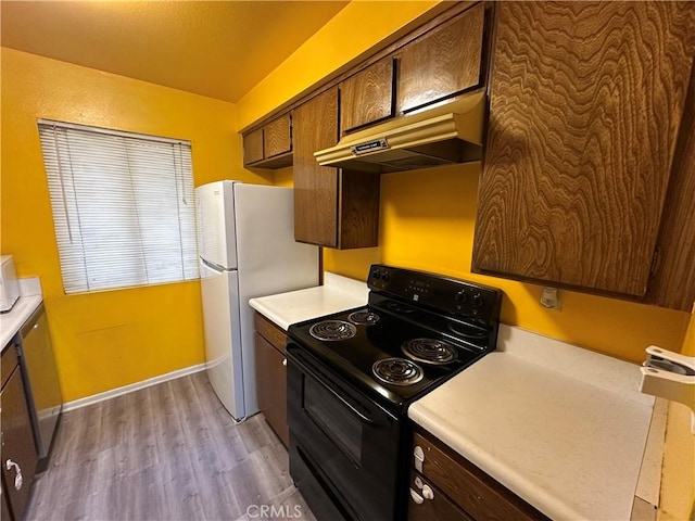 1661 Neil Armstrong St Unit 246, Montebello, CA 90640 - kitchen featuring black / electric stove, under cabinet range hood, light countertops, and light wood finished floors