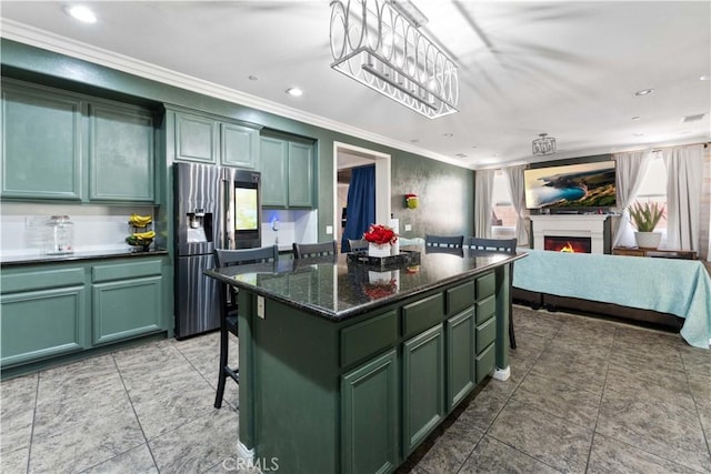 4803 Hawk Ridge Ave, Fontana, CA 92336 - kitchen with green cabinets, stainless steel refrigerator with ice dispenser, ornamental molding, a warm lit fireplace, and a breakfast bar area