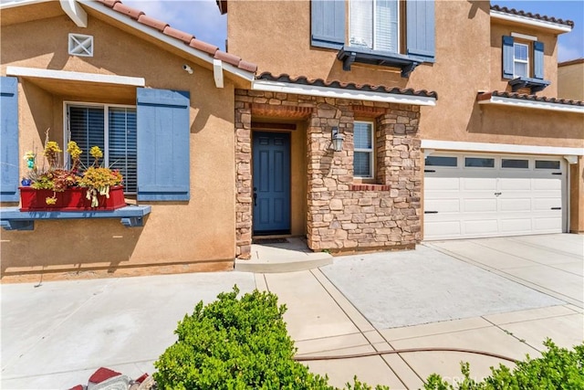 4803 Hawk Ridge Ave, Fontana, CA 92336 - doorway to property featuring stone siding, an attached garage, and a tiled roof