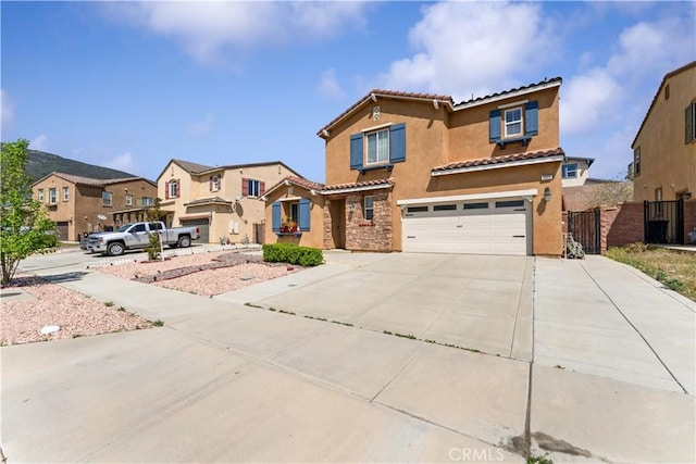 4803 Hawk Ridge Ave, Fontana, CA 92336 - mediterranean / spanish house with a tiled roof, a garage, stucco siding, concrete driveway, and a residential view