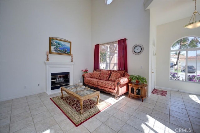 932 Provance Ave, Santa Maria, CA 93458 - living room with a towering ceiling, light tile patterned flooring, a glass covered fireplace, and baseboards