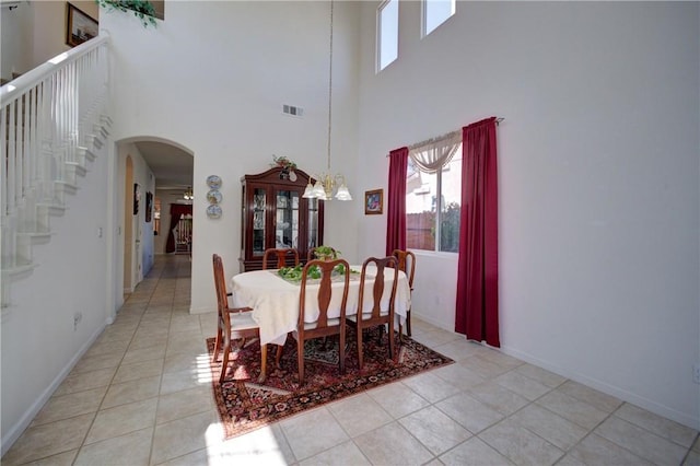 932 Provance Ave, Santa Maria, CA 93458 - dining area with arched walkways, a chandelier, light tile patterned flooring, a towering ceiling, and stairs