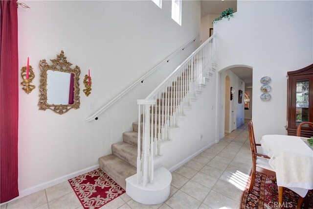 932 Provance Ave, Santa Maria, CA 93458 - stairway featuring arched walkways, tile patterned flooring, a high ceiling, and baseboards