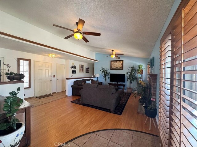 7446 Bangor Ave, Hesperia, CA 92345 - living area featuring tile patterned floors, a fireplace, a ceiling fan, and a textured ceiling