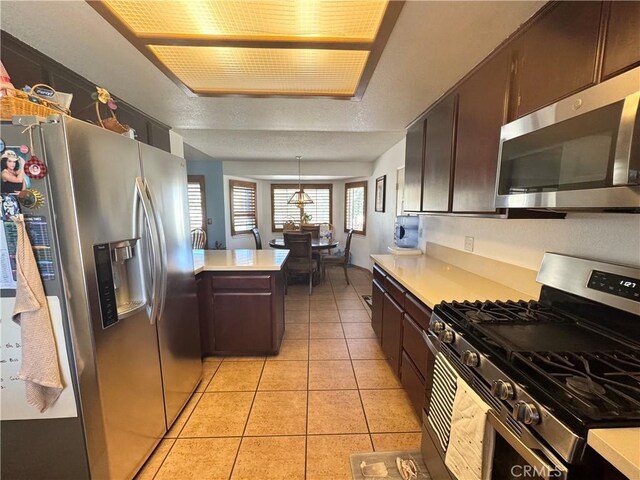 7446 Bangor Ave, Hesperia, CA 92345 - kitchen featuring appliances with stainless steel finishes, light countertops, light tile patterned floors, and dark brown cabinets