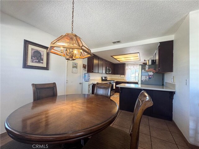 7446 Bangor Ave, Hesperia, CA 92345 - dining area featuring a chandelier, a textured ceiling, and tile patterned floors