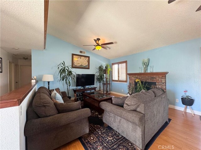 7446 Bangor Ave, Hesperia, CA 92345 - living area featuring a ceiling fan, a textured ceiling, light wood-style flooring, baseboards, and vaulted ceiling