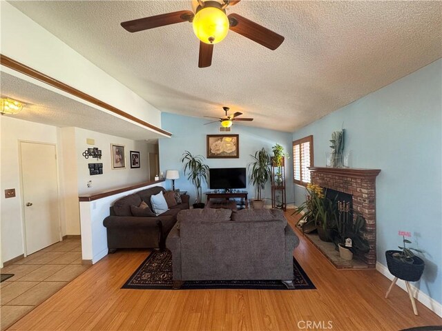 7446 Bangor Ave, Hesperia, CA 92345 - living room featuring a fireplace, a textured ceiling, a ceiling fan, wood finished floors, and lofted ceiling