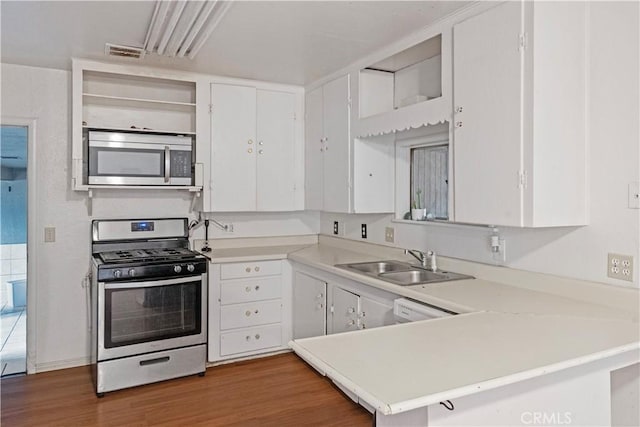 5219 Fleming Rd, Atwater, CA 95301 - kitchen with stainless steel appliances, open shelves, a sink, light countertops, and wood finished floors