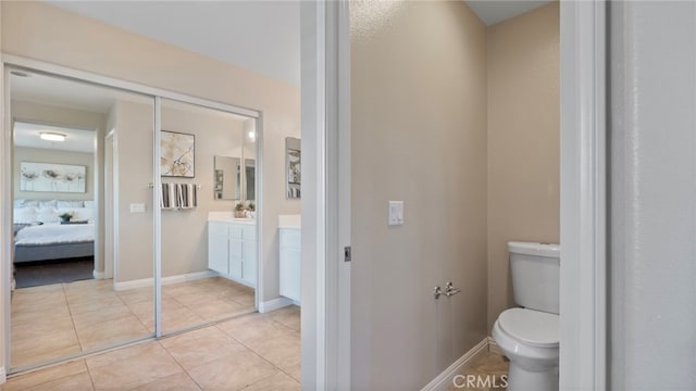 77 Crocus St, Redlands, CA 92373 - bathroom featuring vanity, toilet, ensuite bathroom, tile patterned flooring, and baseboards
