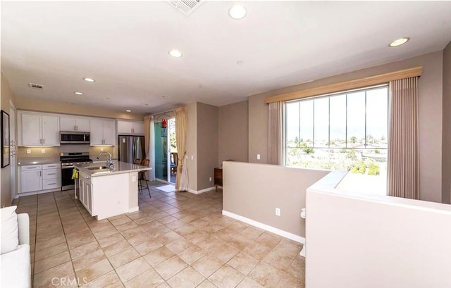 713 S Azusa Ave Unit A, Azusa, CA 91702 - kitchen featuring appliances with stainless steel finishes, light countertops, white cabinets, recessed lighting, and a kitchen island with sink