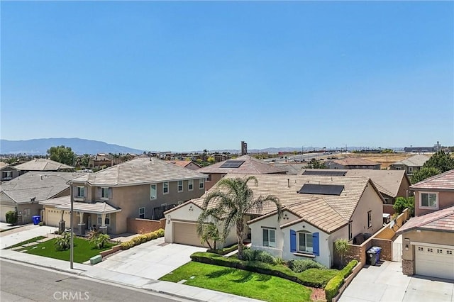 6125 Coopers Hawk Dr, Jurupa Valley, CA 91752 - traditional-style house featuring concrete driveway, a residential view, a garage, and a mountain view