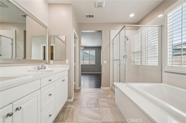 6125 Coopers Hawk Dr, Jurupa Valley, CA 91752 - full bathroom with a bath, a shower stall, double vanity, and baseboards