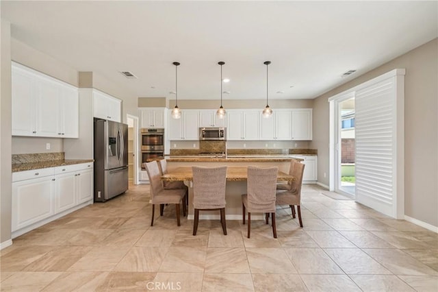 6125 Coopers Hawk Dr, Jurupa Valley, CA 91752 - kitchen with stainless steel appliances, white cabinets, an island with sink, and recessed lighting