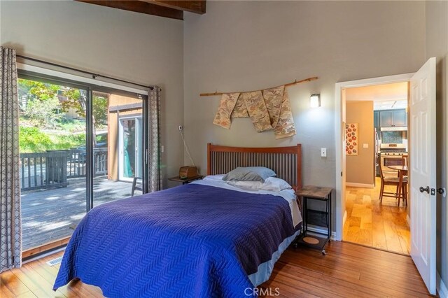 31045 Valley Oak Dr, Running Springs, CA 92382 - bedroom featuring hardwood / wood-style floors, access to outside, beamed ceiling, and a towering ceiling