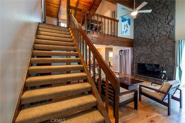 31045 Valley Oak Dr, Running Springs, CA 92382 - stairway with ceiling fan, high vaulted ceiling, wood finished floors, wood ceiling with exposed beams, and a stone fireplace