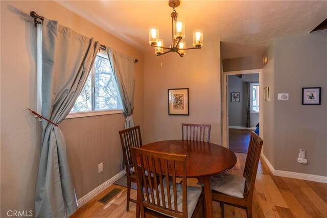 31045 Valley Oak Dr, Running Springs, CA 92382 - dining room with a chandelier, healthy amount of natural light, and light wood-type flooring