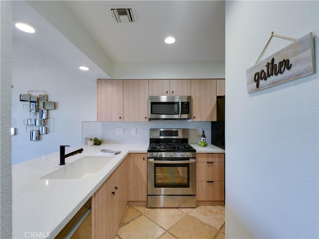 316 Forest Hills Dr, Rancho Mirage, CA 92270 - kitchen featuring appliances with stainless steel finishes, light brown cabinetry, a sink, tasteful backsplash, and light countertops