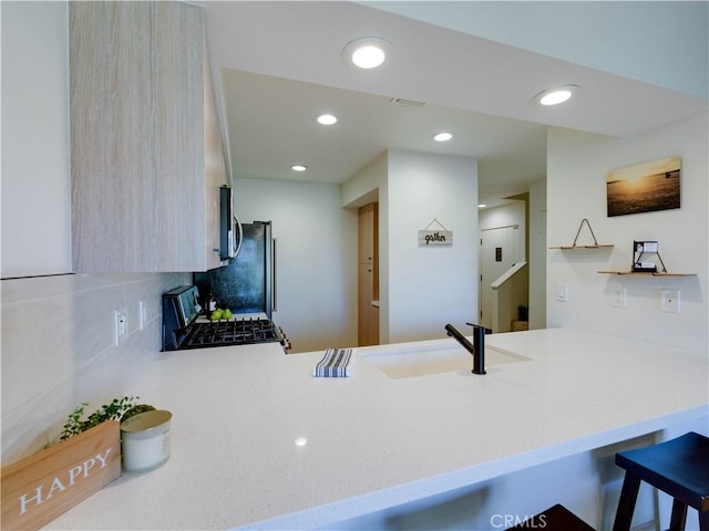 316 Forest Hills Dr, Rancho Mirage, CA 92270 - kitchen featuring a peninsula, a sink, range with gas stovetop, tasteful backsplash, and recessed lighting