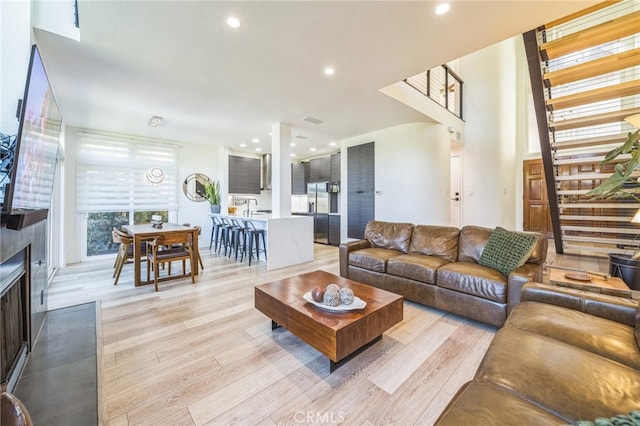 528 San Andres Dr, Solana Beach, CA 92075 - living area featuring light wood finished floors, stairway, recessed lighting, and a fireplace with flush hearth