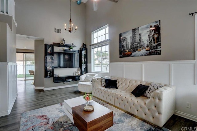 29567 Castlewood Dr, Menifee, CA 92584 - living room featuring a high ceiling, a chandelier, wood finished floors, a decorative wall, and wainscoting