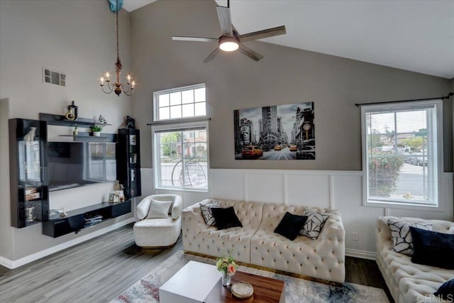 29567 Castlewood Dr, Menifee, CA 92584 - living area with wood finished floors, high vaulted ceiling, a chandelier, a ceiling fan, and a wainscoted wall