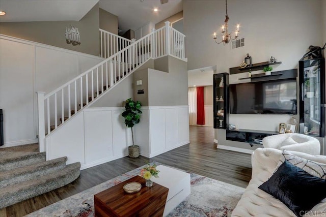 29567 Castlewood Dr, Menifee, CA 92584 - living area with stairs, wood finished floors, high vaulted ceiling, a chandelier, and a decorative wall