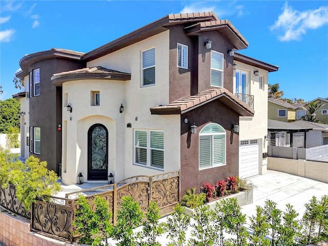 19002 Delaware St, Huntington Beach, CA 92648 - mediterranean / spanish house featuring a garage, a fenced front yard, driveway, a tiled roof, and stucco siding