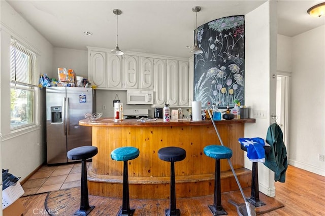 831 Rio Chico Way, Chico, CA 95928 - kitchen featuring stainless steel fridge with ice dispenser, white microwave, stove, white cabinets, and a peninsula