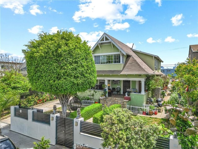 1522 2nd Ave, Los Angeles, CA 90019 - view of front of property featuring a fenced front yard, stucco siding, a gate, covered porch, and roof with shingles
