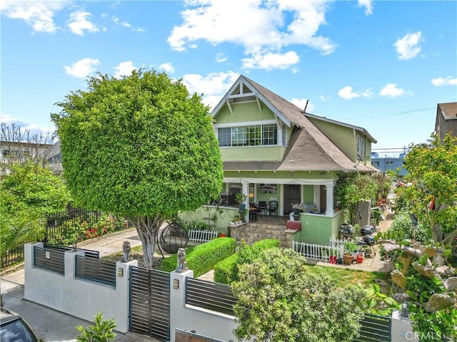 1522 2nd Ave, Los Angeles, CA 90019 - view of front of home with a fenced front yard, stucco siding, a gate, a porch, and a shingled roof