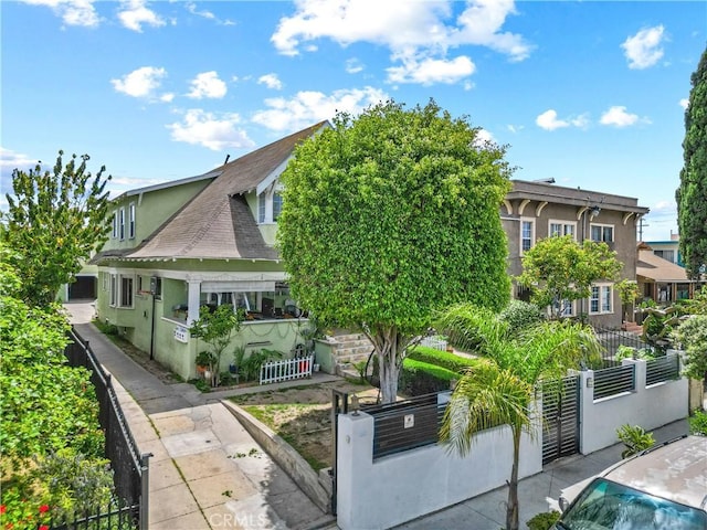 1522 2nd Ave, Los Angeles, CA 90019 - view of front facade featuring a fenced front yard, stucco siding, and a shingled roof