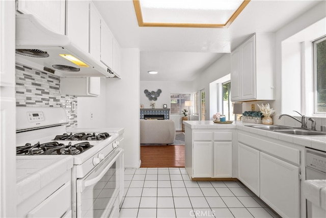 10274 Corkwood Ct, Rancho Cucamonga, CA 91737 - kitchen with white gas stove, a sink, tile countertops, a fireplace, and white cabinetry