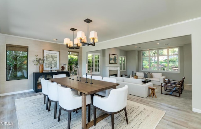 2320 Mountain Ave, La Crescenta, CA 91214 - dining area with a chandelier, baseboards, light wood finished floors, a fireplace, and crown molding
