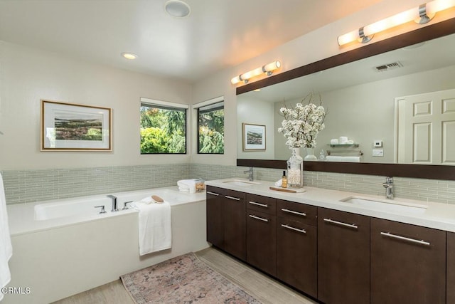 2320 Mountain Ave, La Crescenta, CA 91214 - bathroom featuring wood finished floors, a garden tub, double vanity, tasteful backsplash, and recessed lighting