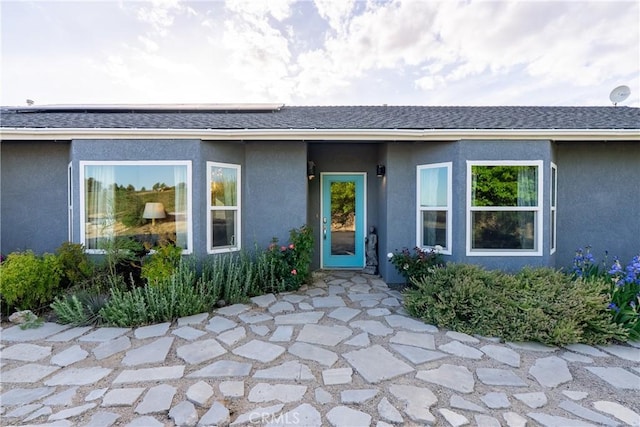 2750 Lazy Hill Rd, San Miguel, CA 93451 - entrance to property featuring stucco siding, roof mounted solar panels, and a shingled roof