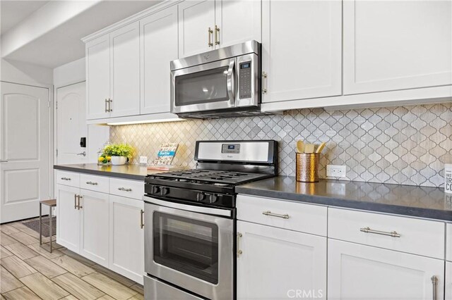405 Mallorca Ln, Brea, CA 92823 - kitchen with stainless steel appliances, dark countertops, tasteful backsplash, and white cabinets