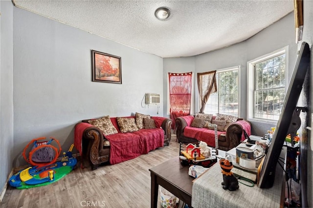 673 W 9th St, San Bernardino, CA 92410 - living room featuring a textured ceiling, wood finished floors, and a wall mounted air conditioner