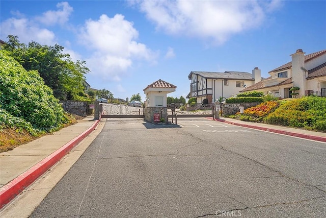 16227 Glencove Dr, Hacienda Heights, CA 91745 - view of asphalt street featuring a gate, curbs, a gated entry, and sidewalks