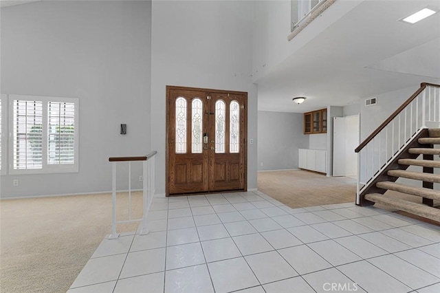 16227 Glencove Dr, Hacienda Heights, CA 91745 - entryway with light colored carpet, a towering ceiling, baseboards, stairs, and light tile patterned flooring