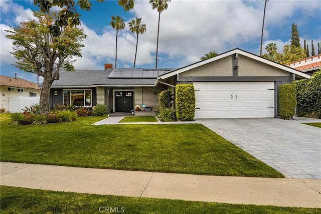 1624 Kingston Rd, Placentia, CA 92870 - single story home featuring a front lawn, decorative driveway, an attached garage, solar panels, and a chimney