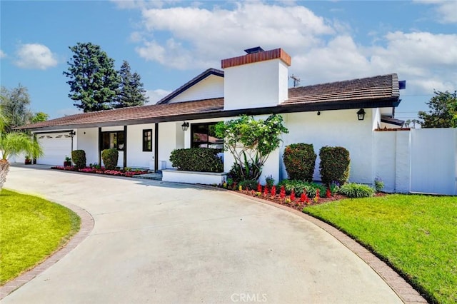 12312 Eveningside Dr, Santa Ana, CA 92705 - view of front of property with a front yard, an attached garage, concrete driveway, stucco siding, and a porch