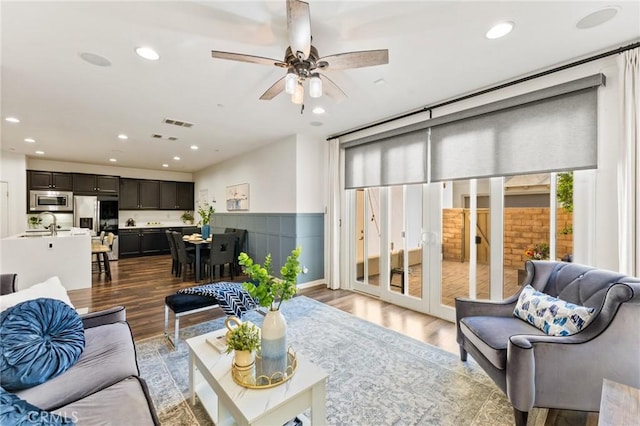 2974 E Walking Beam Pl, Brea, CA 92821 - living area featuring dark wood-style floors, recessed lighting, ceiling fan, wainscoting, and french doors