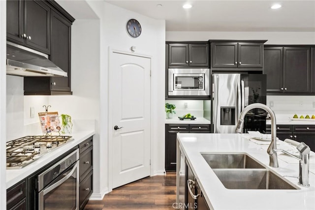 2974 E Walking Beam Pl, Brea, CA 92821 - kitchen featuring appliances with stainless steel finishes, a sink, under cabinet range hood, dark wood-style flooring, and light countertops