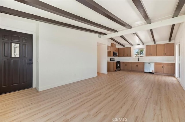 unfurnished living room with a sink, light wood-type flooring, and baseboards