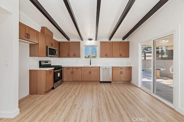 kitchen featuring appliances with stainless steel finishes, light wood-style floors, beam ceiling, light countertops, and a sink