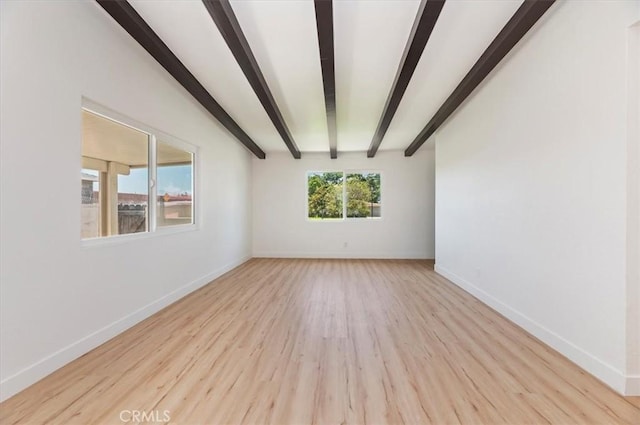 unfurnished room featuring beam ceiling, wood finished floors, and baseboards