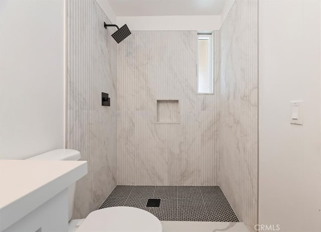 bathroom with toilet and a tile shower