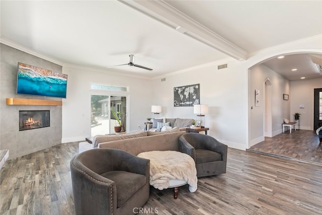 38855 Bella Vista Rd, Temecula, CA 92592 - living room with arched walkways, wood finished floors, a ceiling fan, a tile fireplace, and baseboards